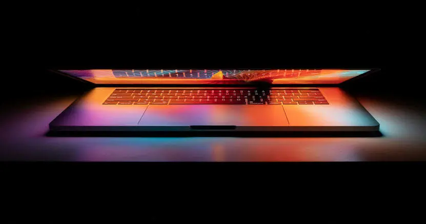 A partially opened laptop with a glowing screen
